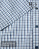Close-up of a blue and white checkered shirt with buttons, featuring 'DG's Drifter' branding.