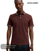 Studio portrait of a man wearing a Jack and Jones fire brick red piqué polo shirt with a tipped collar.