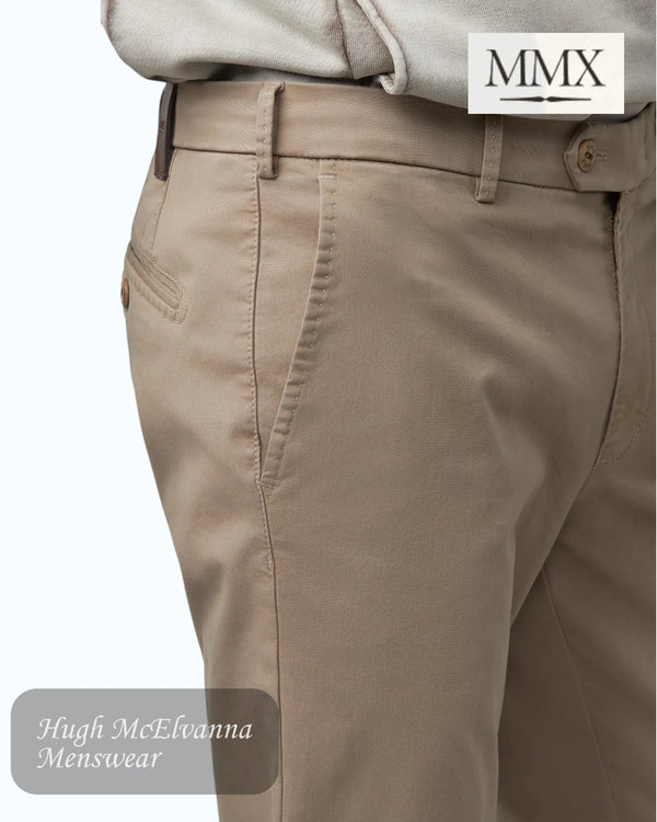 Beige pants with a close-up of the waistband, featuring the MMX brand logo.