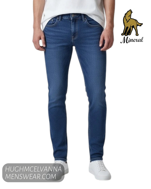 Close up front view of model wearing Mineral ANDRES slim fit stretch jeans with white trainers