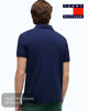 Person wearing a navy blue Tommy Hilfiger polo shirt on a white background