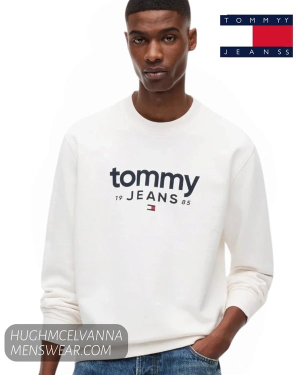 Front view of male model wearing Tommy Jeans Ancient White graphic crew neck sweatshirt with blue jeans