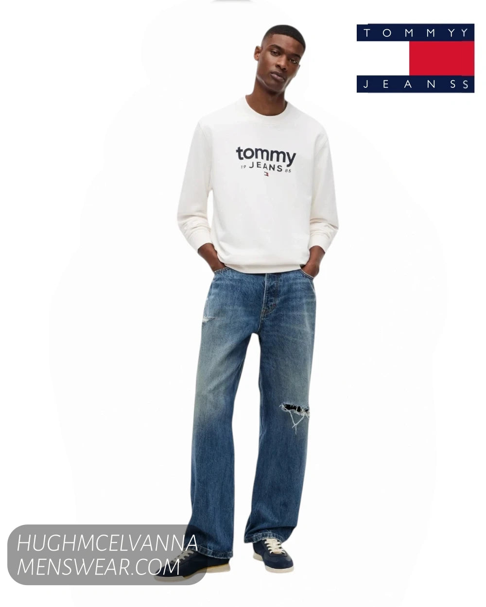 Full length model view wearing Tommy Jeans ancient white sweatshirt with relaxed blue denim jeans and navy trainers