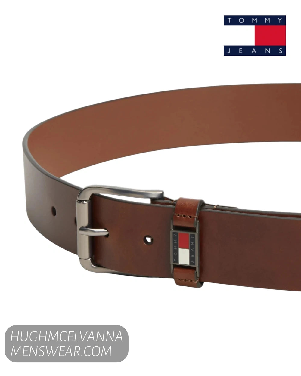 Angled close up view of Tommy Jeans winter cognac brown leather belt showing flag badge detail