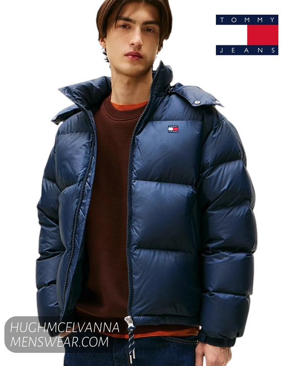 Tommy Jeans Alaska navy puffer jacket, layered over a brown crewneck sweater. 