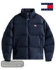 A navy blue Tommy Jeans puffer jacket with a high collar, front zipper, and the classic red, white, and blue Tommy Hilfiger flag logo embroidered on the left chest. 