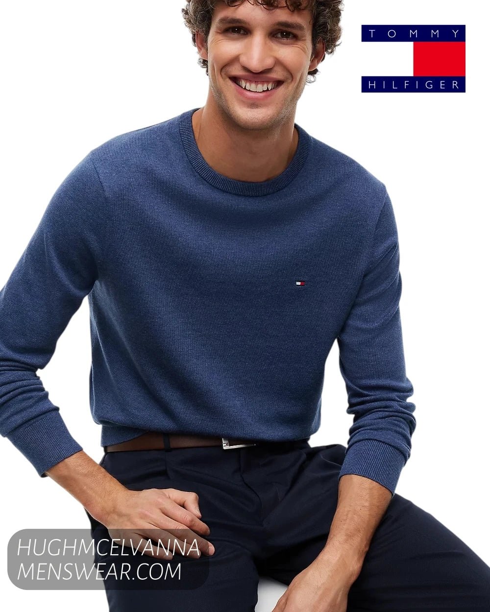 Seated smiling model wearing Tommy Hilfiger Aegean Sea cotton crew neck jumper showing regular fit profile
