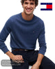 Seated smiling model wearing Tommy Hilfiger Aegean Sea cotton crew neck jumper showing regular fit profile