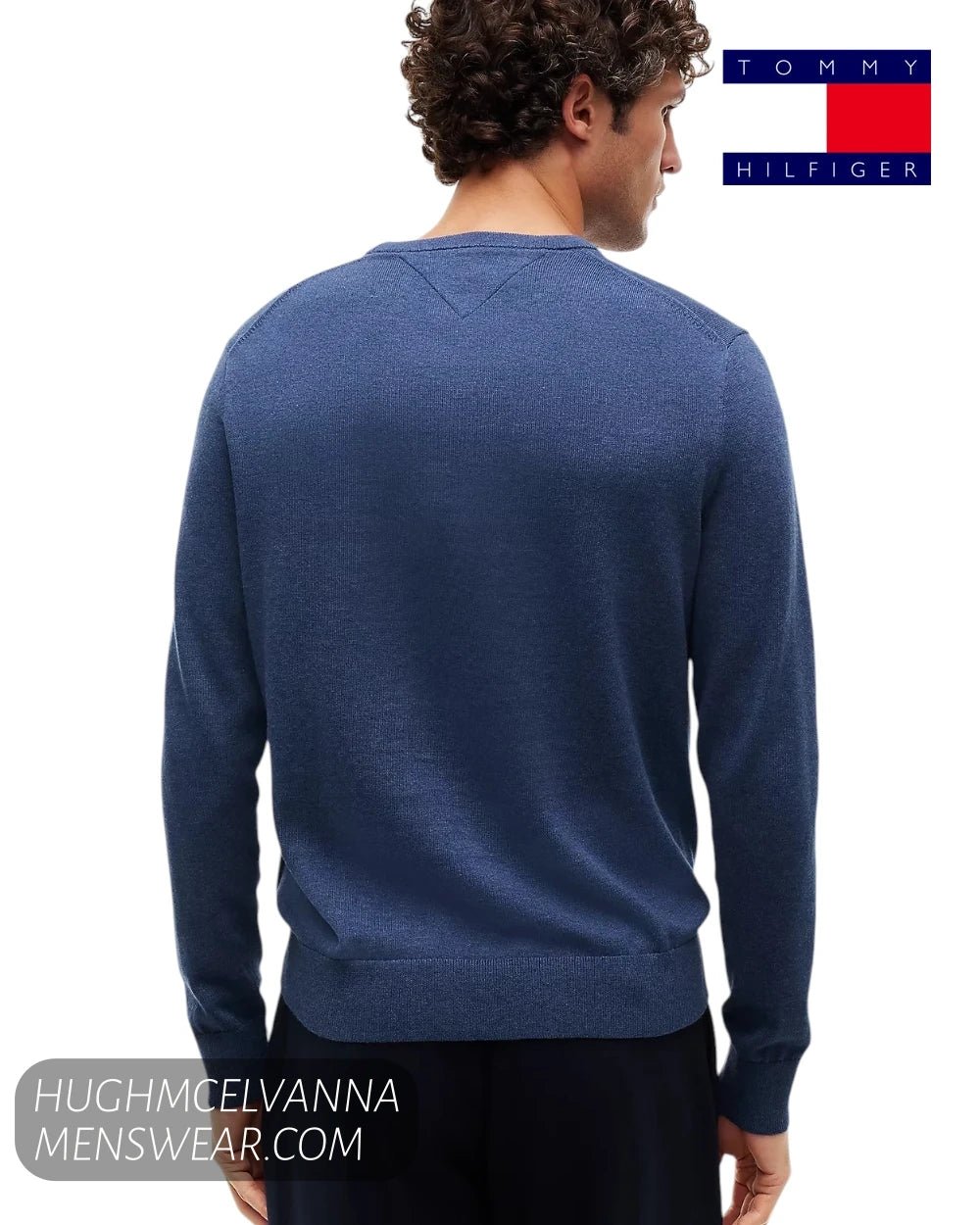 Rear view of male model wearing Tommy Hilfiger blue knit pullover showing clean back yoke and ribbed hem