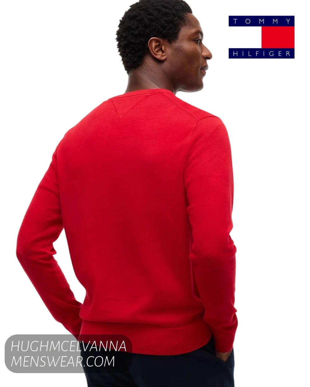 Rear view of male model wearing red Tommy Hilfiger jumper showing clean shoulder tailoring and rib hem
