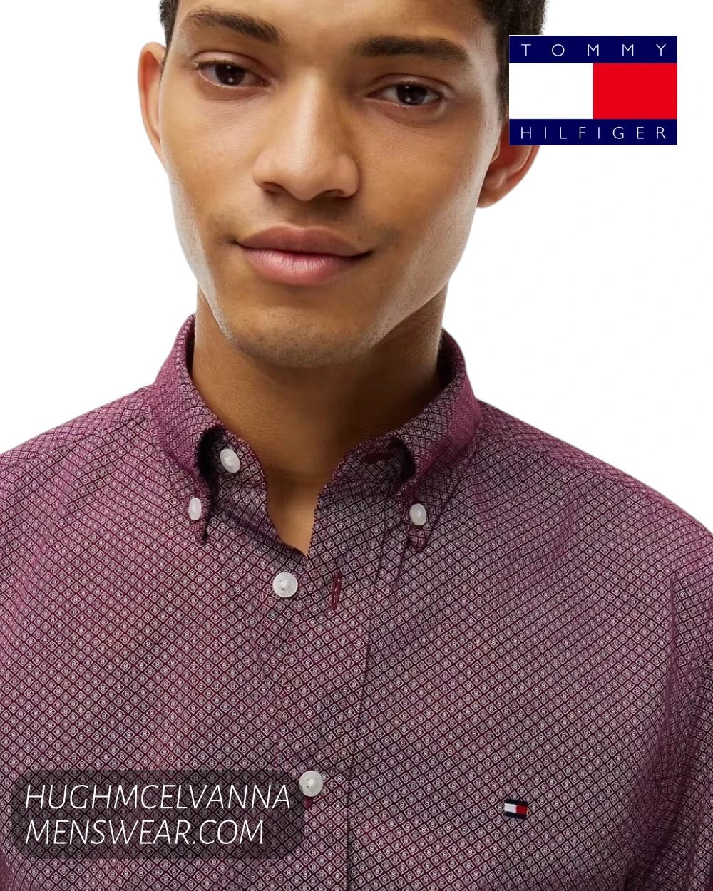 Close up front view of model wearing a Tommy Hilfiger burgundy micro-pattern shirt with white buttons and embroidered chest flag