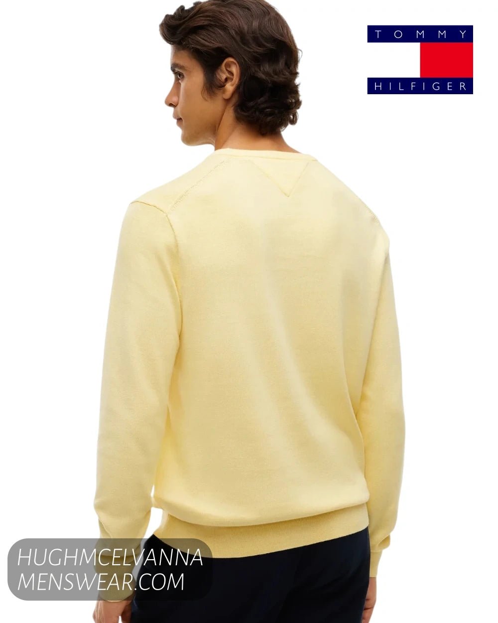 Rear view of male model wearing Tommy Hilfiger Light Daffodil jumper showing back collar stitching and ribbed waistband