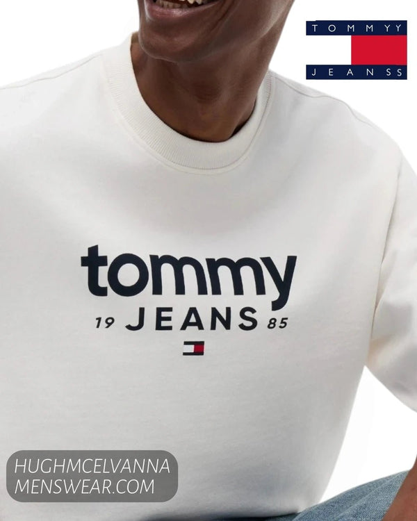Close up front view of Tommy Jeans 1985 chest lettering and embroidered flag logo on ancient white sweatshirt