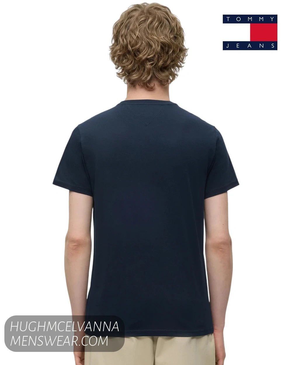 Rear view of male model wearing Tommy Jeans DM0DM23376C1G navy crew neck t-shirt and beige chinos