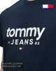 Close up detail of Tommy Jeans navy cotton t-shirt showing white graphic typography and central chest flag