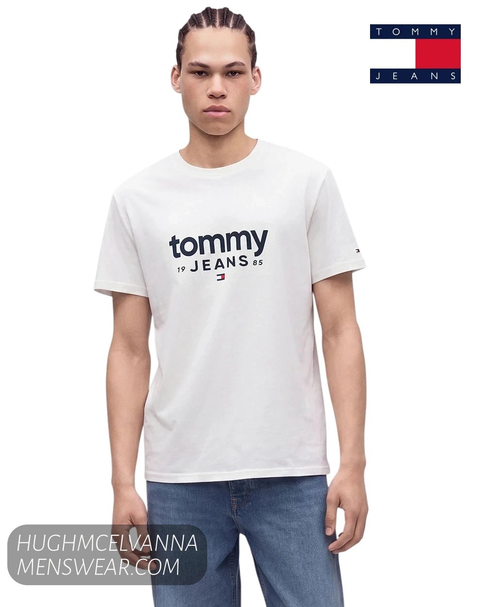 Front view of male model wearing Tommy Jeans white graphic logo t-shirt with hands resting