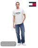 Full length studio model shot wearing Tommy Jeans white logo tee with relaxed blue jeans and white trainers