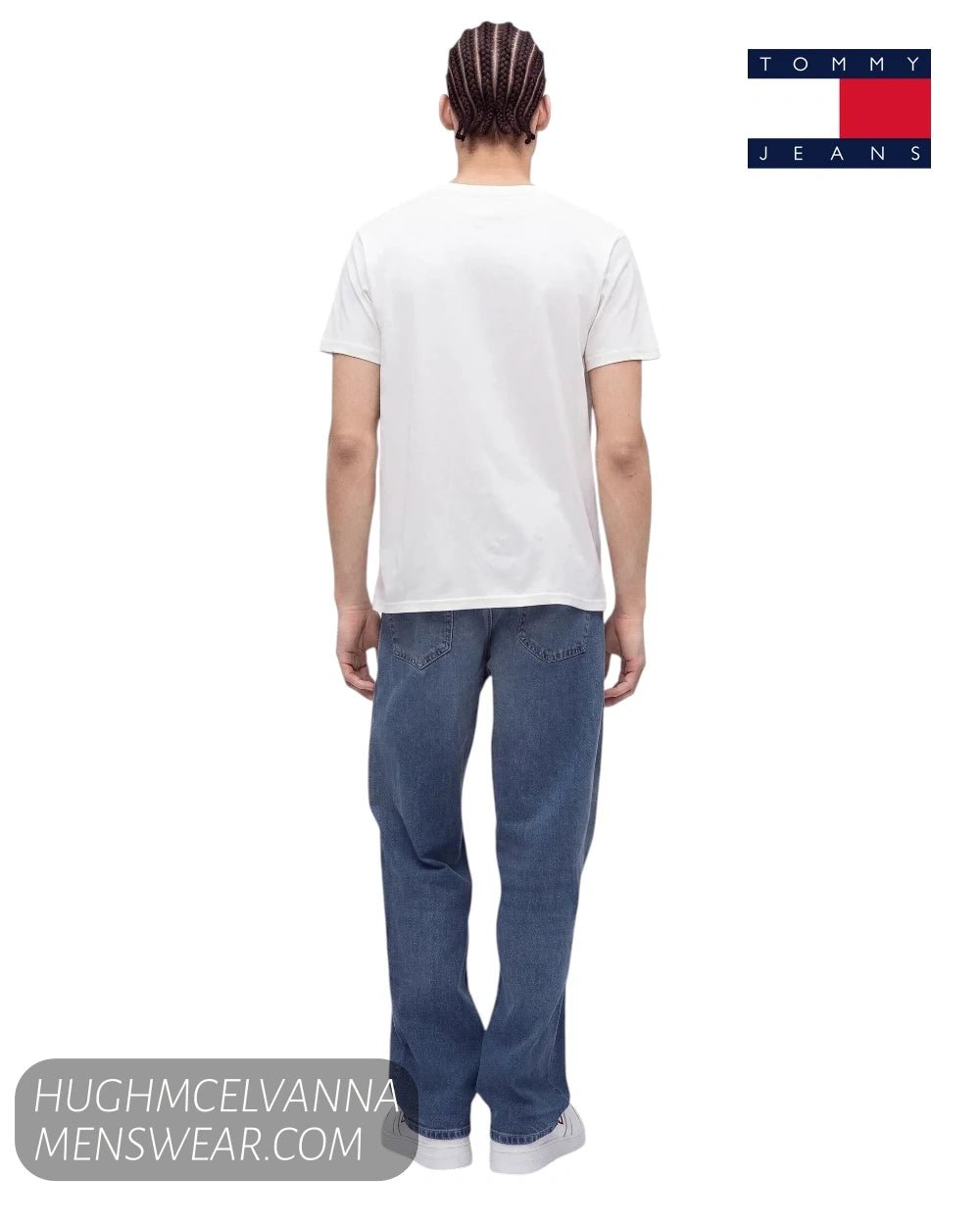 Rear view of model wearing Tommy Jeans DM0DM23376YBH white crew neck t-shirt with blue denim jeans