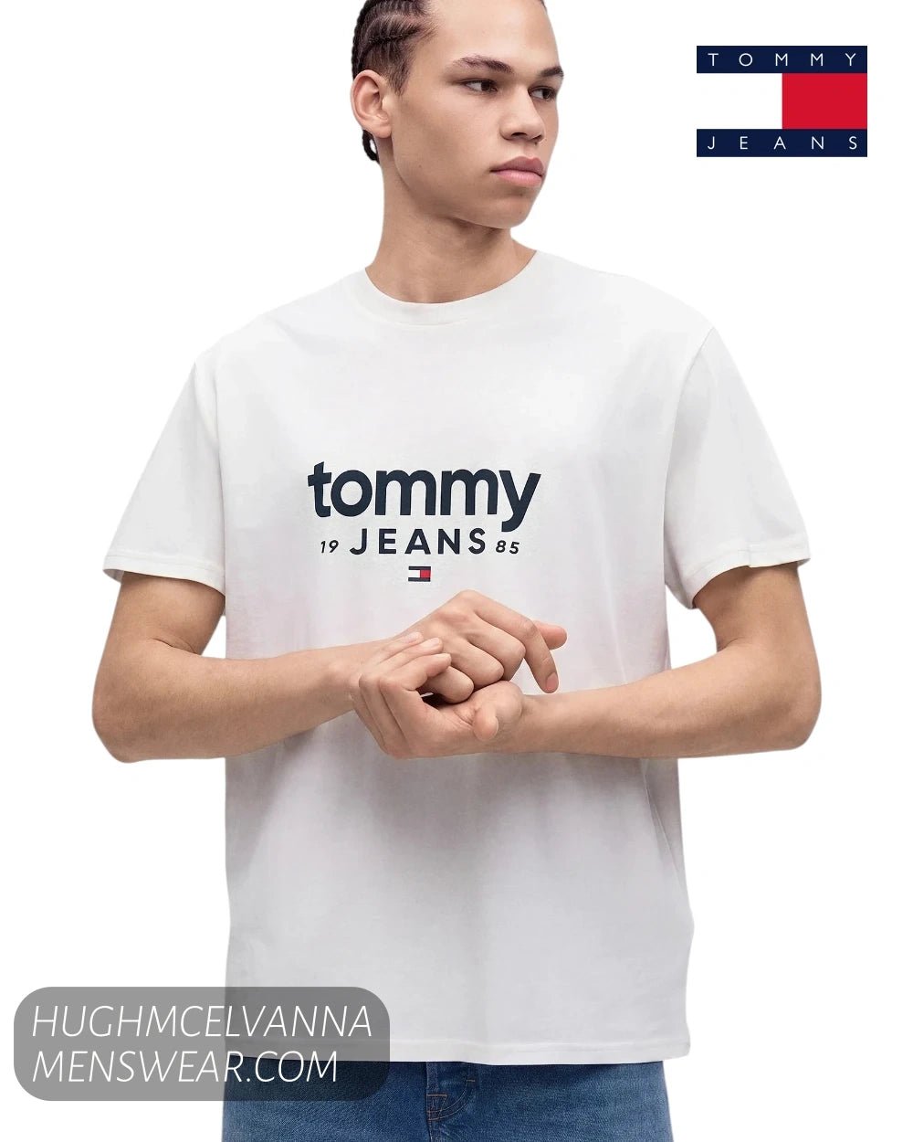 Front studio shot of model wearing Tommy Jeans DM0DM23376 white t-shirt showing left sleeve embroidered flag patch