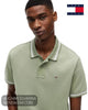 Front chest view of model wearing Tommy Jeans tipped cotton polo shirt in Spring Olive with embroidered flag badge