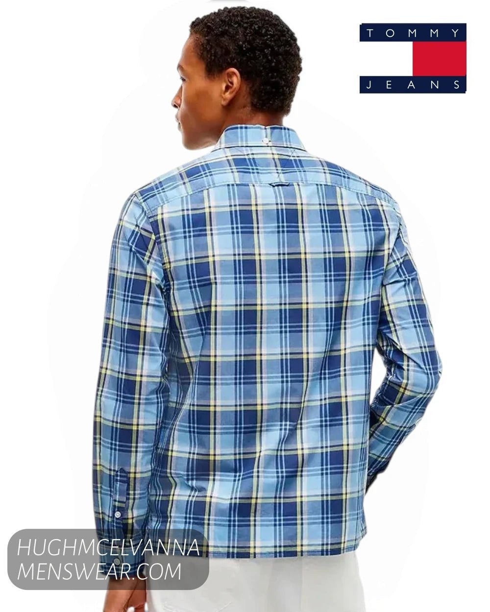 A man wearing a blue plaid long-sleeve shirt by Tommy Jeans, shown from the back against a white background.