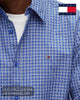 Close up detail of Tommy Jeans Providence Blue grid check cotton fabric, blue buttons, and embroidered chest flag badge